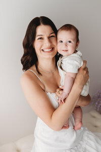 Charleston Mini Sessions - Mother embraces her baby during Mother's Day Mini Session at Holy City Babies in Charleston, SC.
