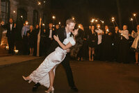 groom dips bride during sparkler exit