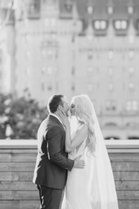 Couple kissing at the NAC rooftop overlooking the Chateau Laurier in Ottawa, Ontario. Photographed by Ottawa wedding photographer Brittany Navin Photography