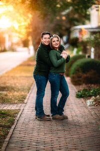 Husband hugging his wife from behind during a fall family photography session in New Bern
