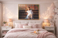 Fine art child portrait in white lace dress seated on brick steps displayed as wall art in a softly styled bedroom