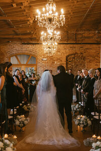 bride escorted into wedding ceremony at Melrose Knitting Mill