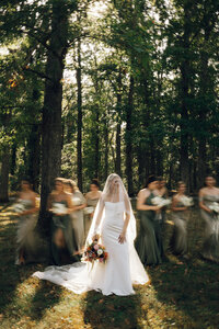 Bridesmaids walking through the woods at Keswick Vineyard wedding with bouquets by Flowergirl Cville, Charlottesville florist | Photo by Abby Hart Photography