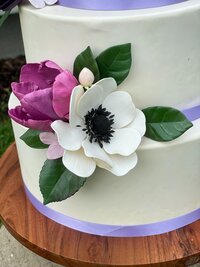 close up of anemone and purple tulip on wedding cake