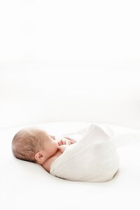 side profile of newborn wrapped and laying on beanbag