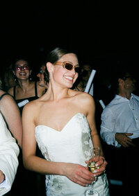 Bride smiling and dancing at her wedding reception surrounded by guests in Huntsville, Alabama.
