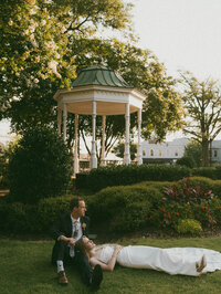 couple laying on grass during wedding photos in atlanta, GA