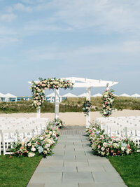 An editorial capture of a floral-lined wedding aisle, showcasing refined composition and intentional imagery for an East Coast wedding at Chatham Bars Inn in Cape Cod.