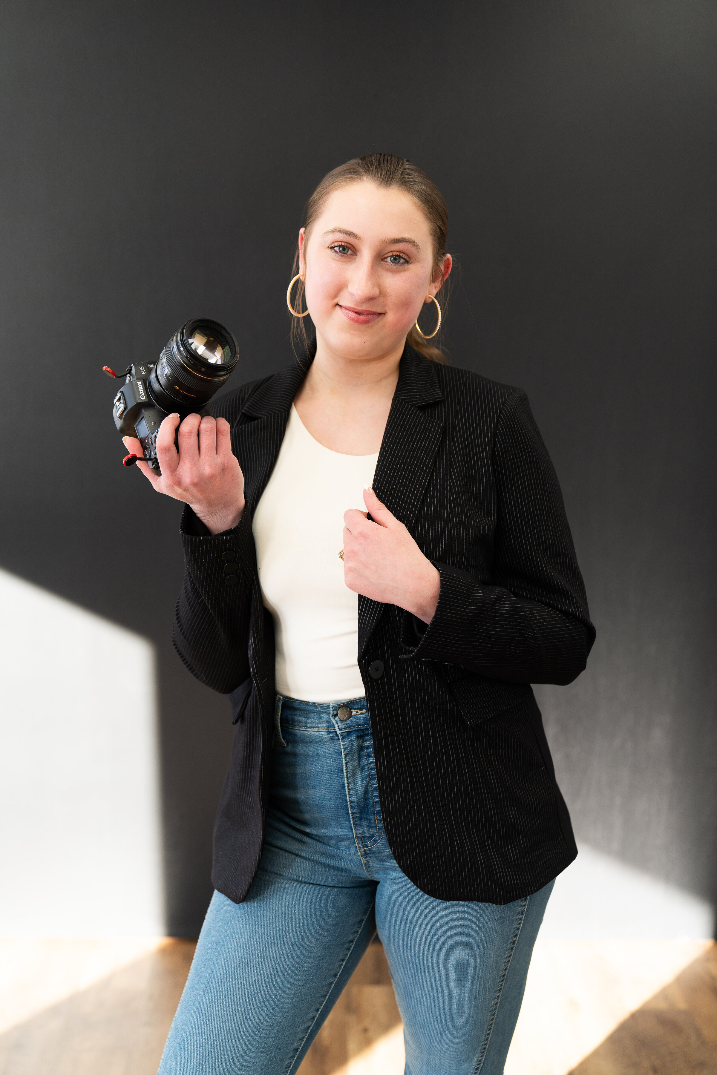 Photographer poses with her camera for her branding photo shoot