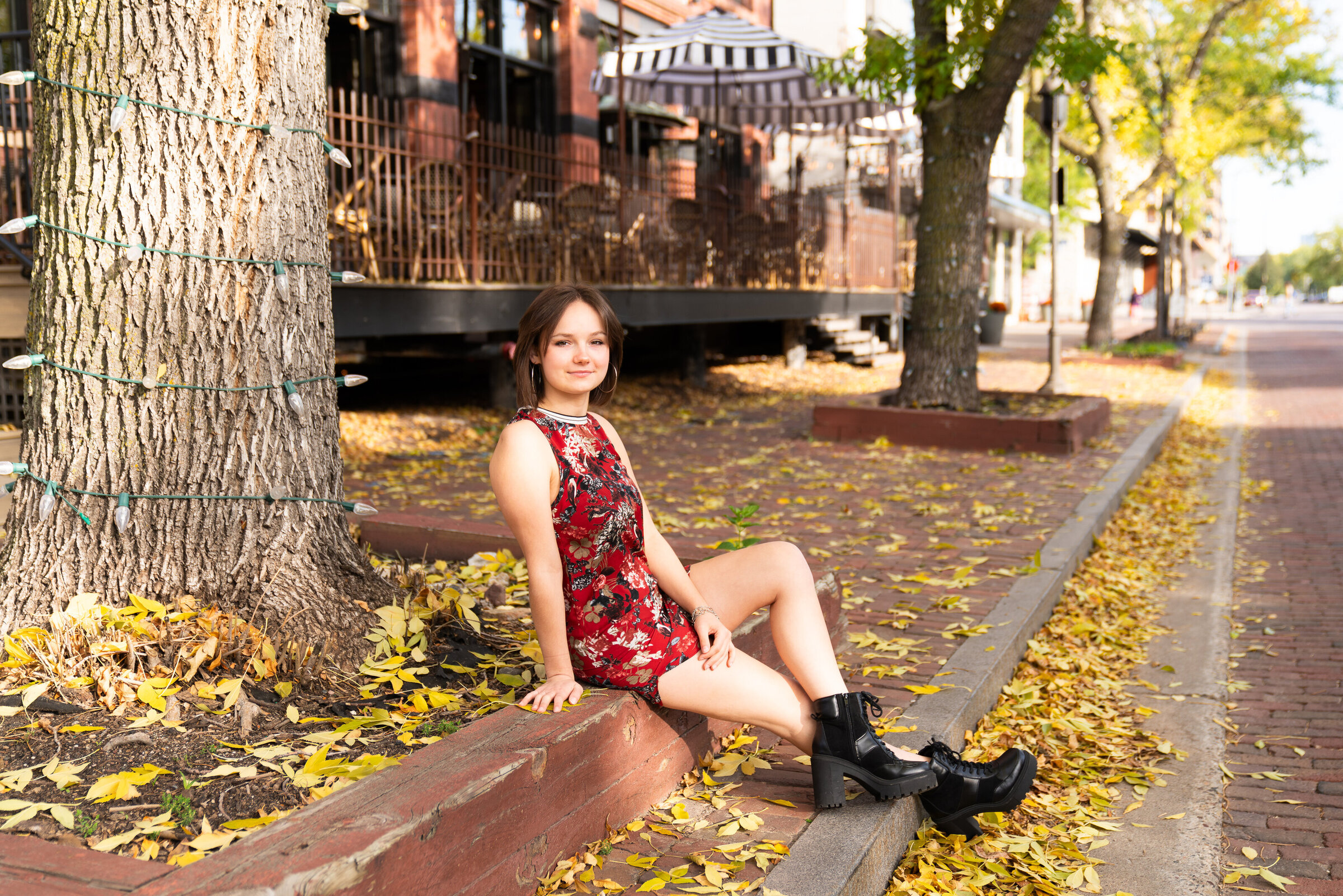 Girl sits on a ledge along St. Anthony Main in Minneapolis, Minnesota