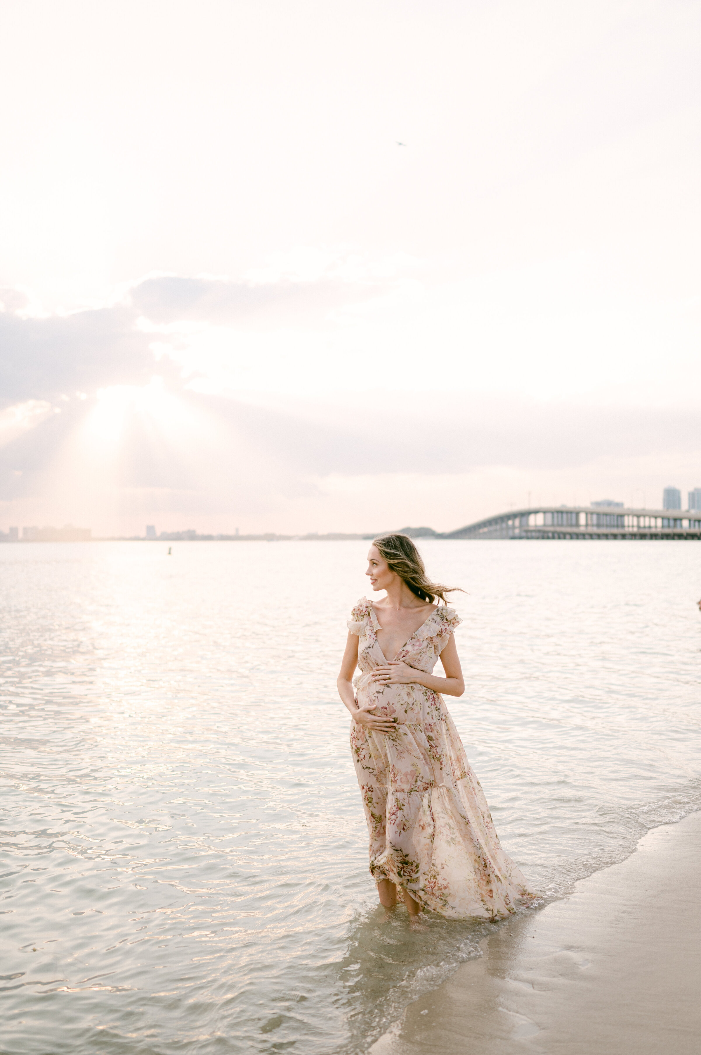 Pregnant woman looking at the sunset with Miami skyline