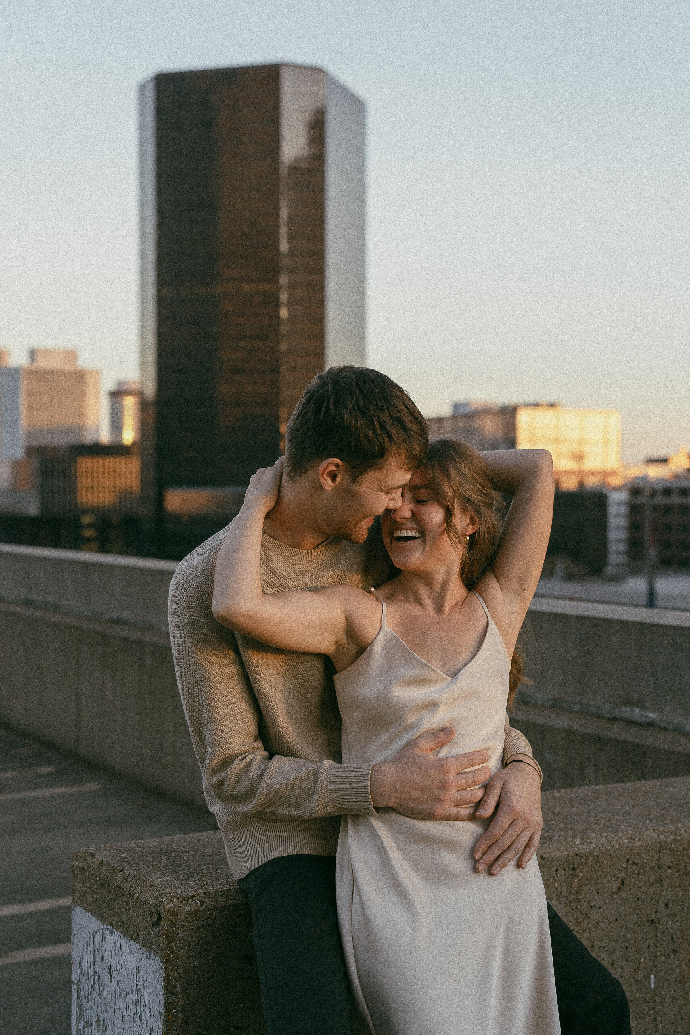 Couple hugging with a city skyline in the background.