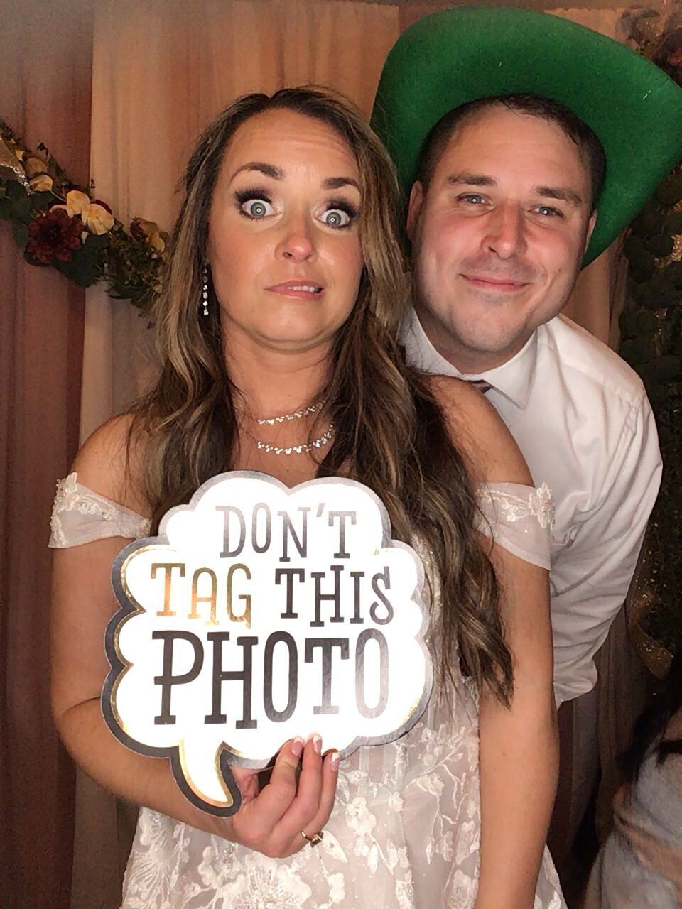 Bride with funny sign and friend