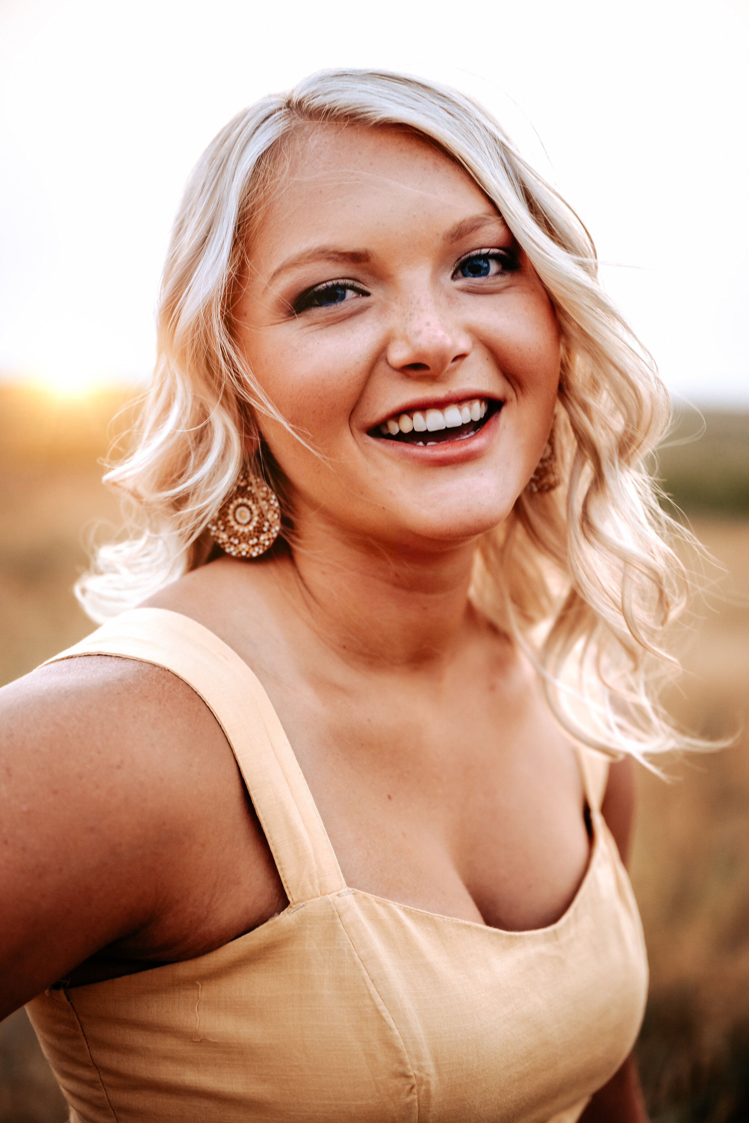 laughing senior photos that look natural while girl wears yellow dress