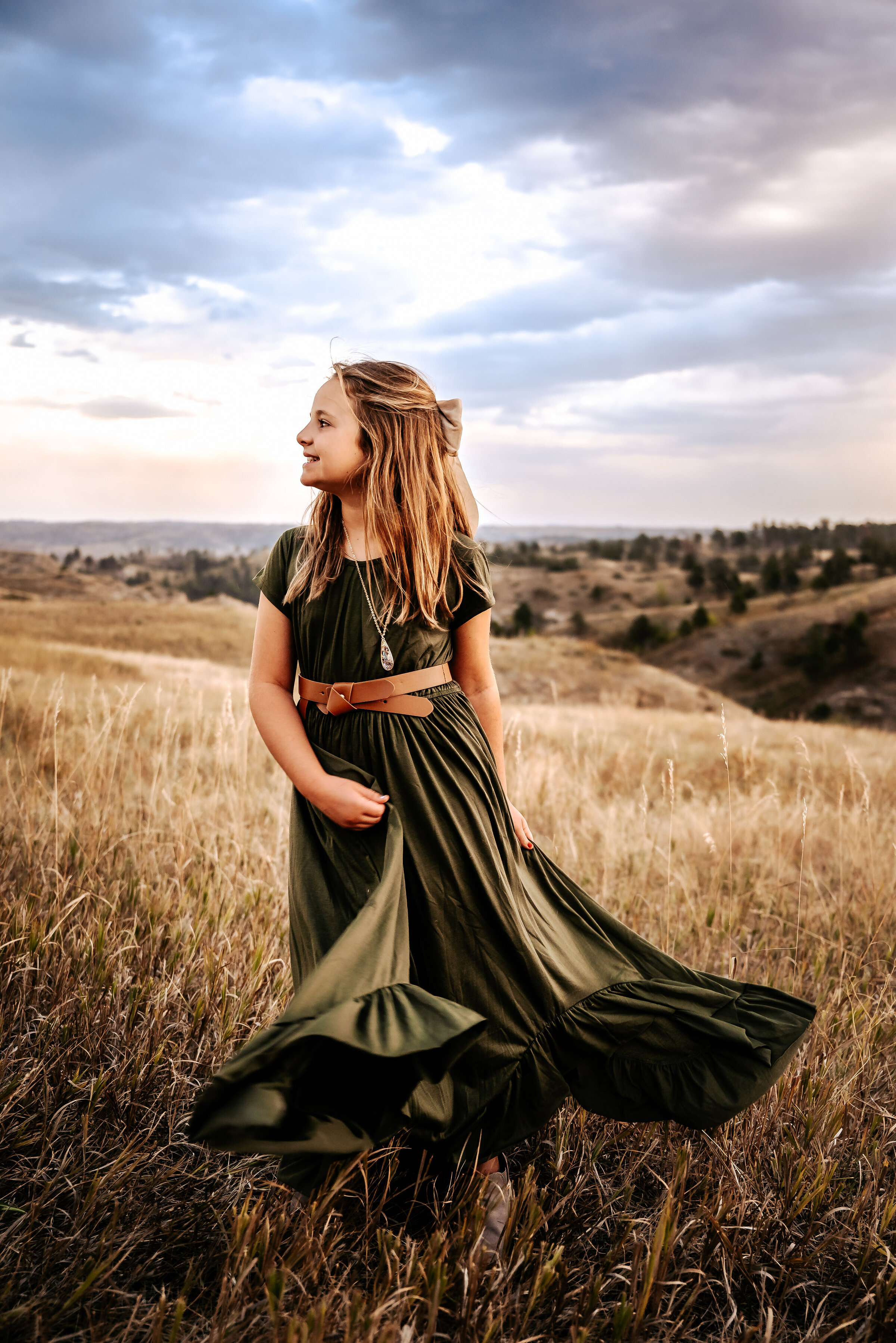 Girl smiles and twirls green dress in chadron state park