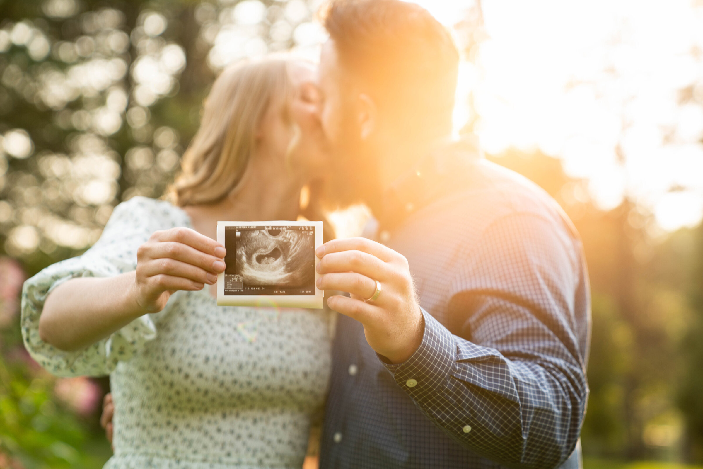 Couple holding an ultrasound photo for their pregnancy announcement photo shoot