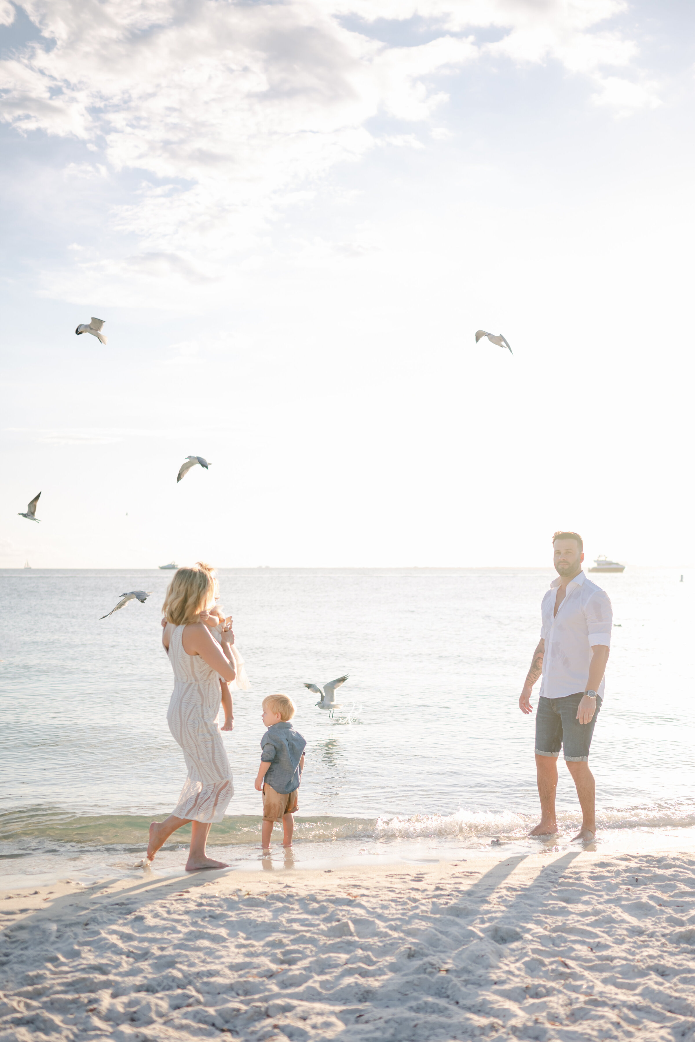 Family and birds flying at sunset by Miami Family Photographer
