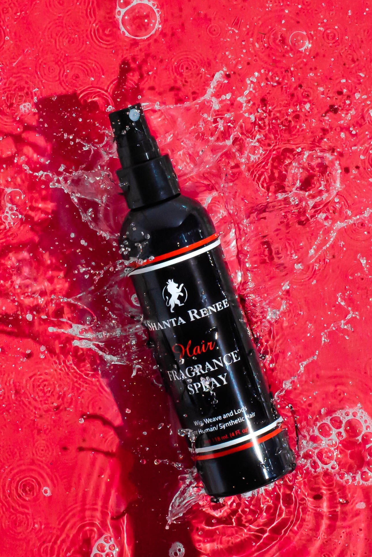 black bottle of haircare product splashing into water with red background