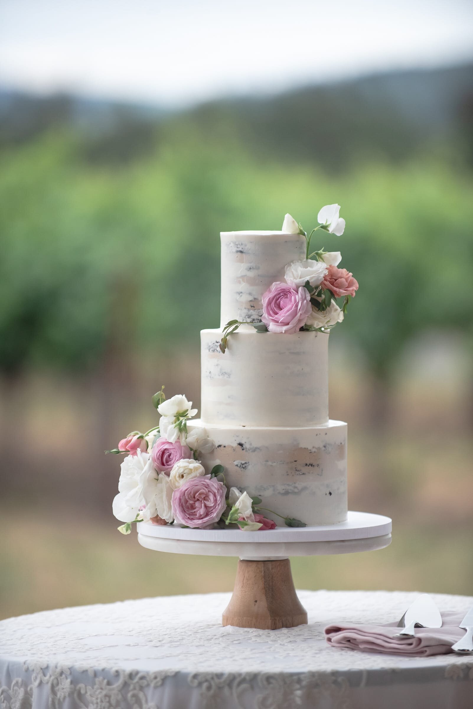naked wedding cake with white and pink florals. Destination wedding photography.