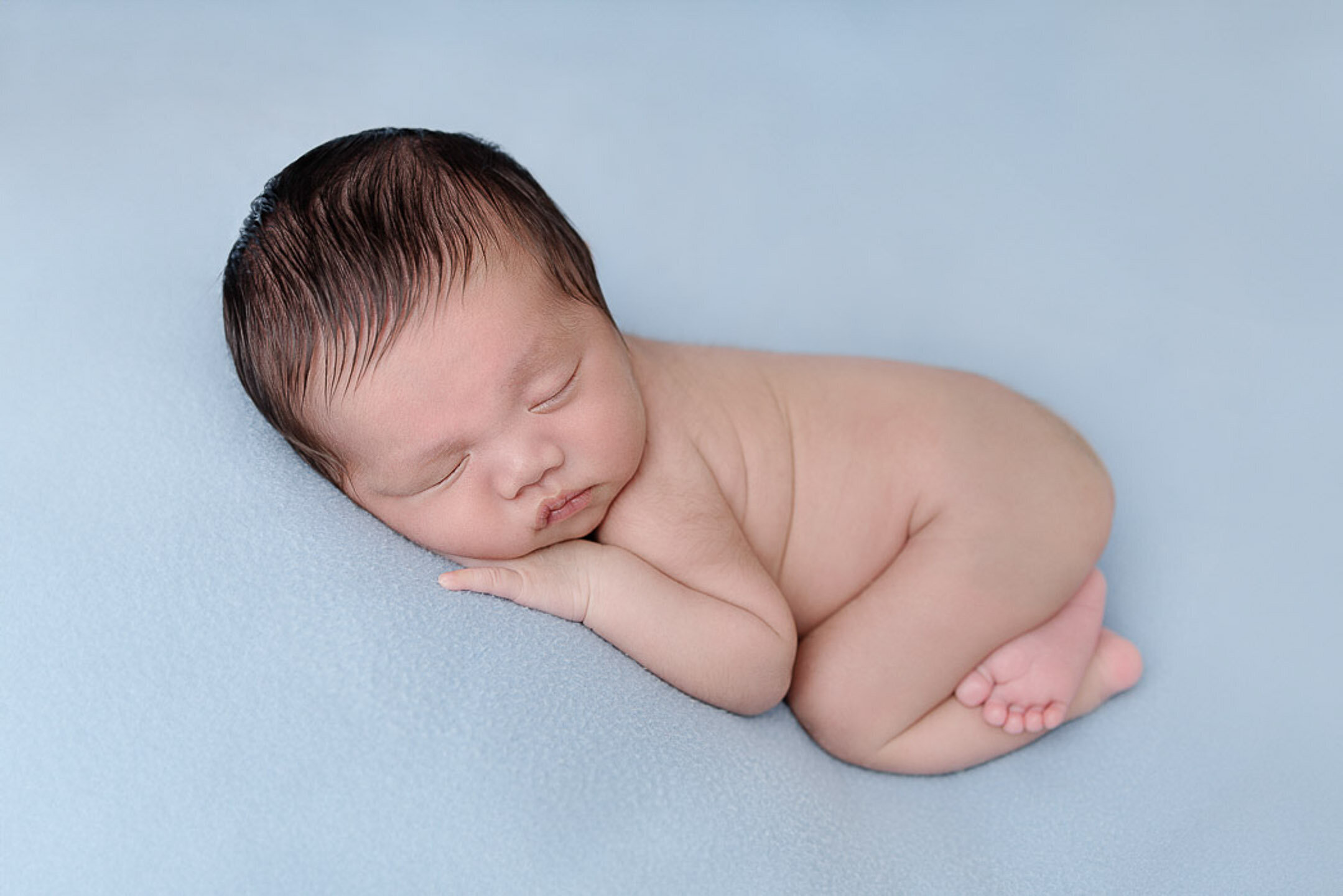 baby boy sleeping on a blue fabric
