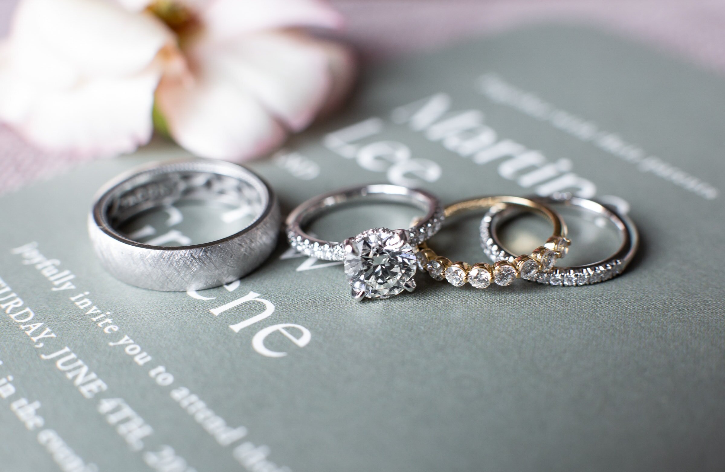 wedding rings against sage wedding invitation