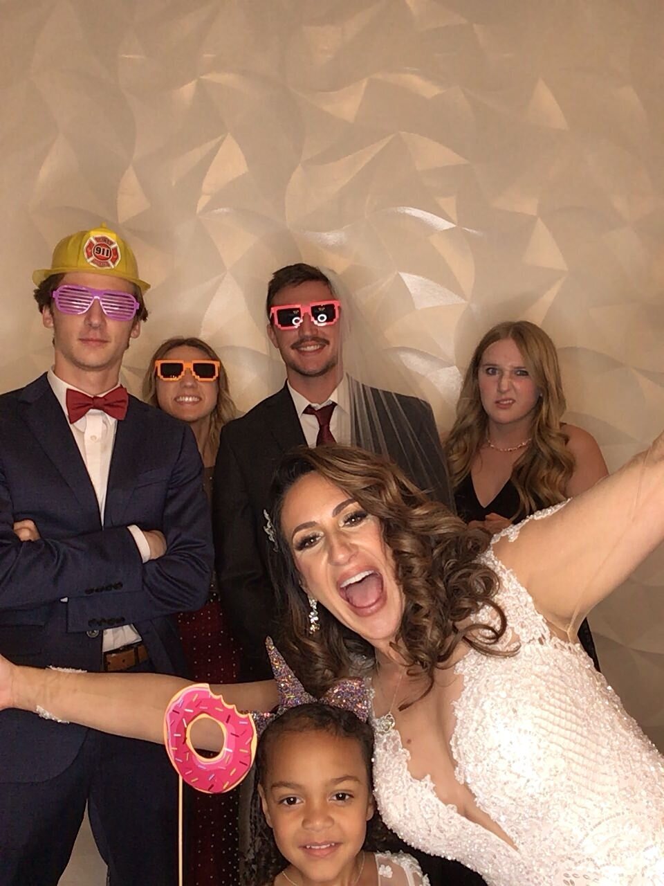 Bride surprises guests by jumping into photobooth with them