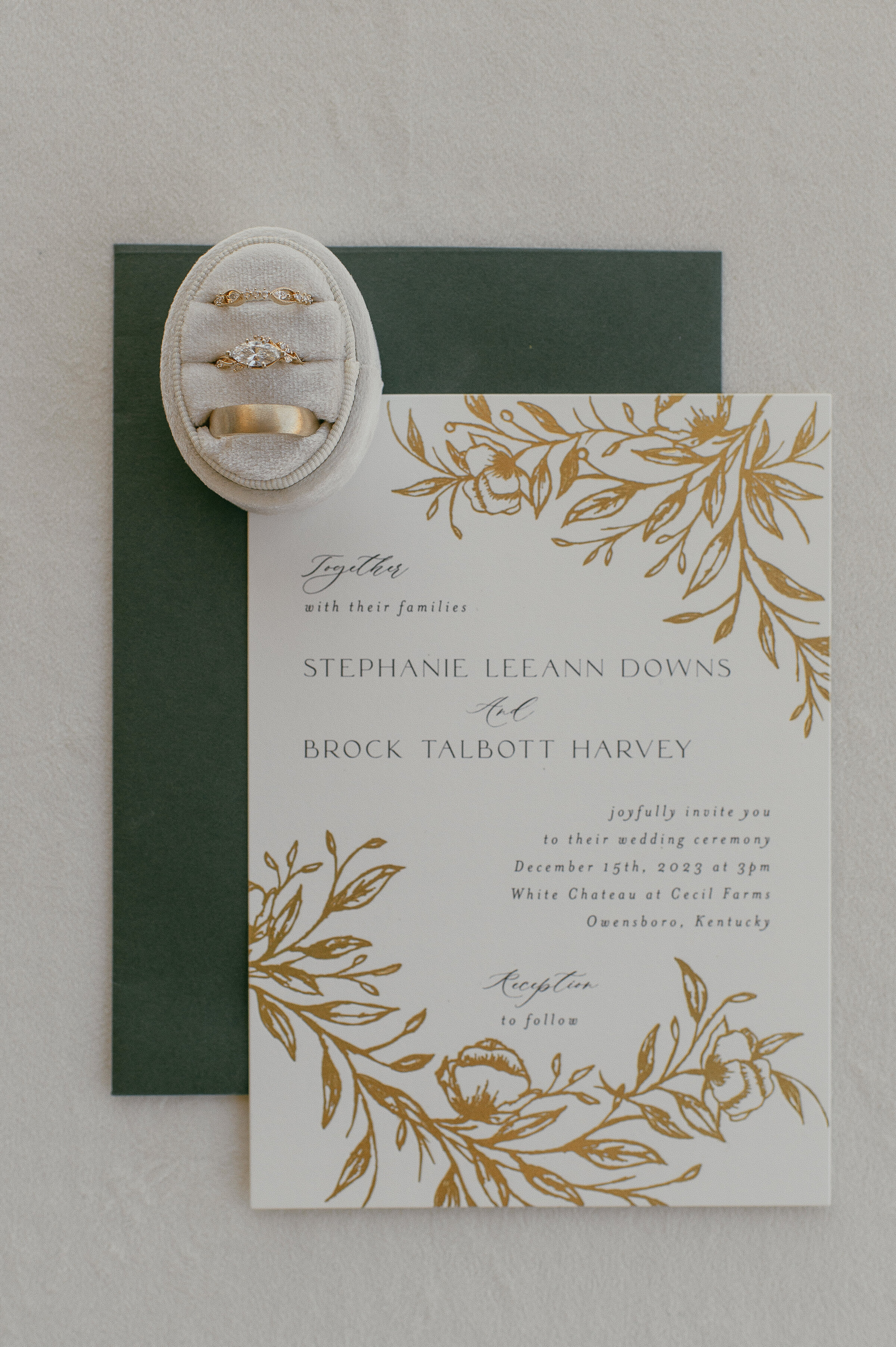 Wedding invitation and rings, showcasing the couple's names and wedding details.