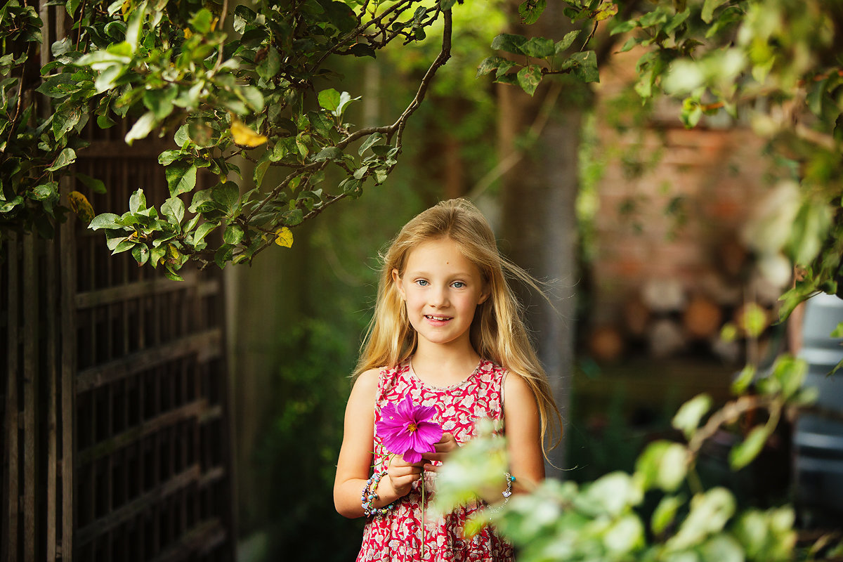 little girl holding a flower in the garden