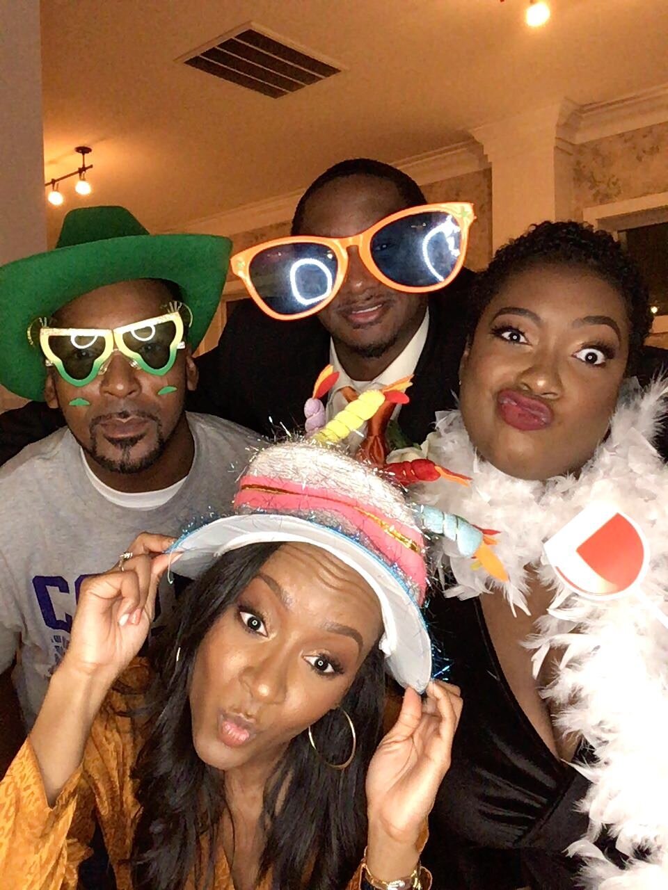 Group of Four together rocking hats and glasses at Wilburn Street Wedding Venue photobooth