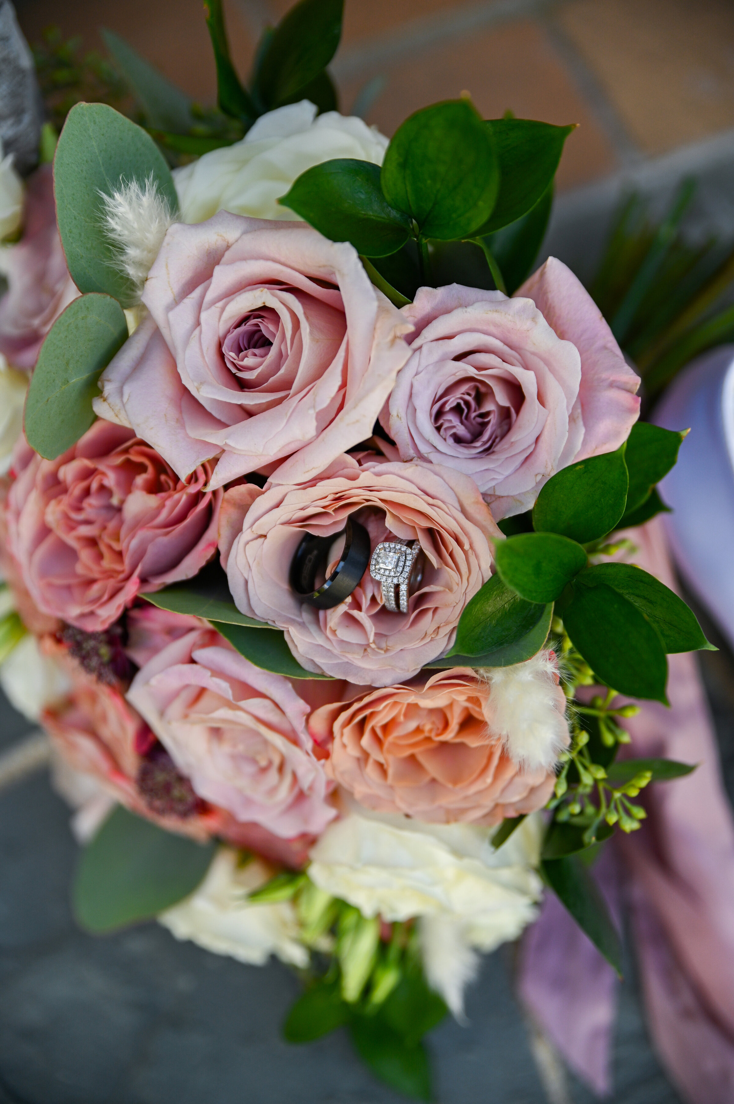 Pink and purple roses with wedding rings on top