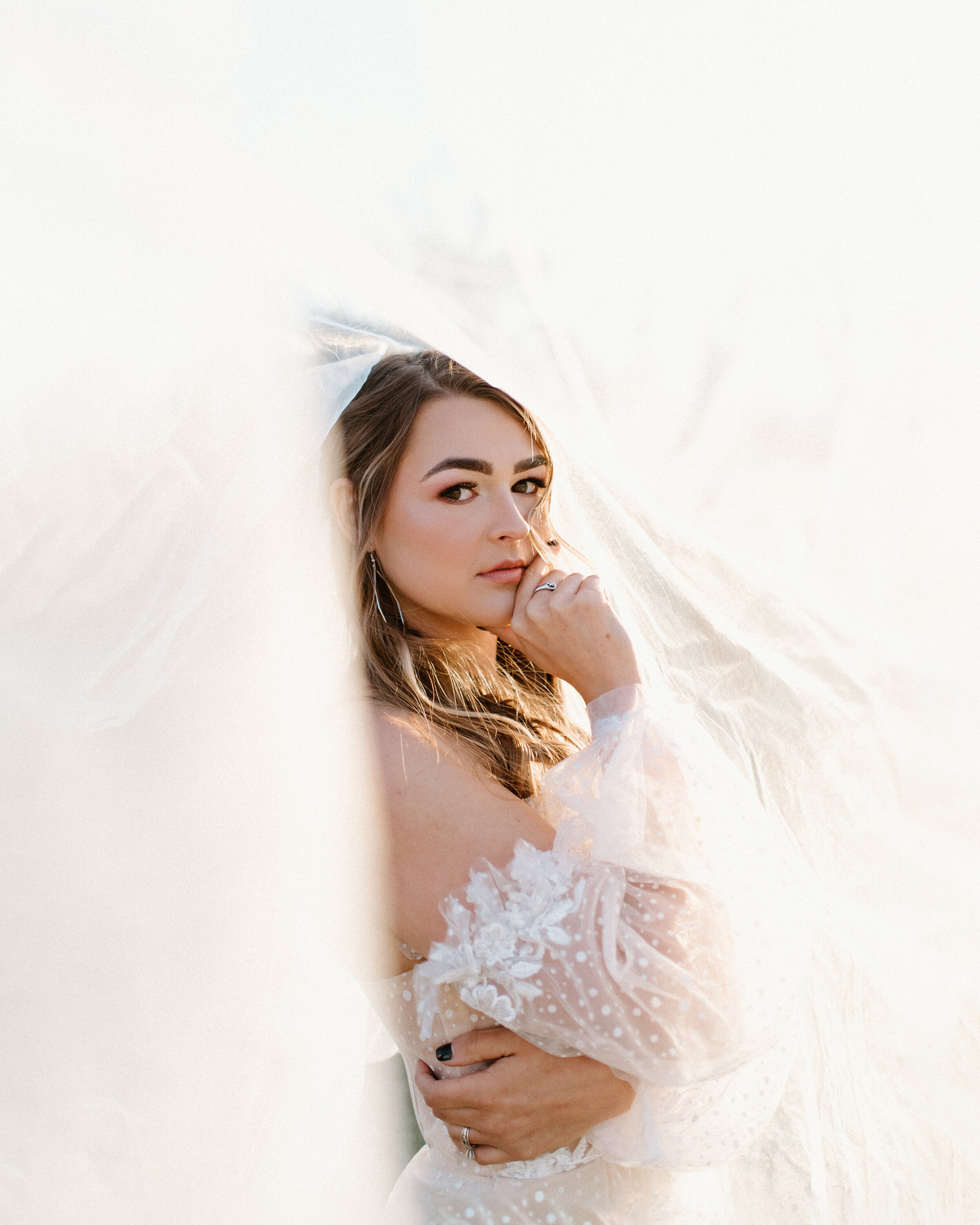 Bride posing underneath veil