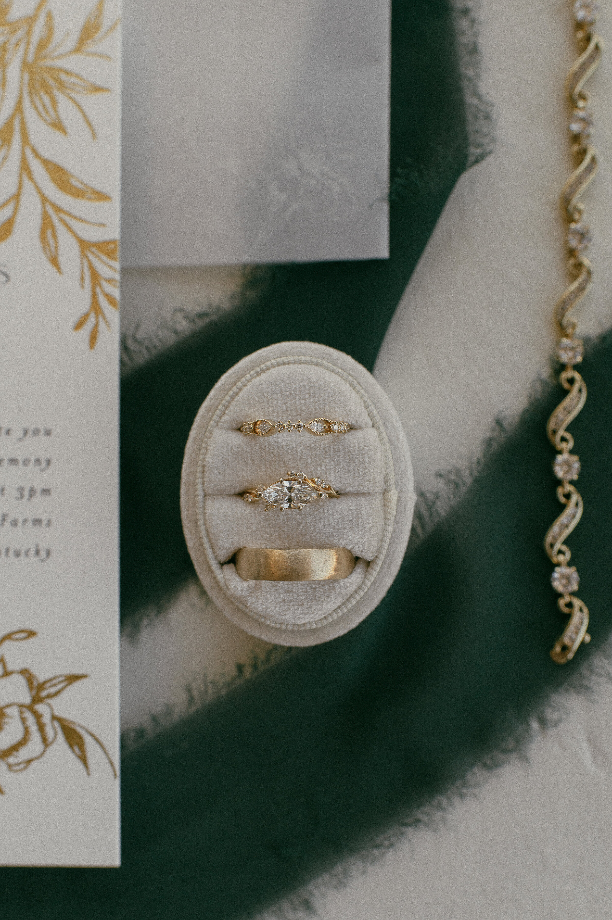 Close-up of wedding rings in velvet box with invitation background