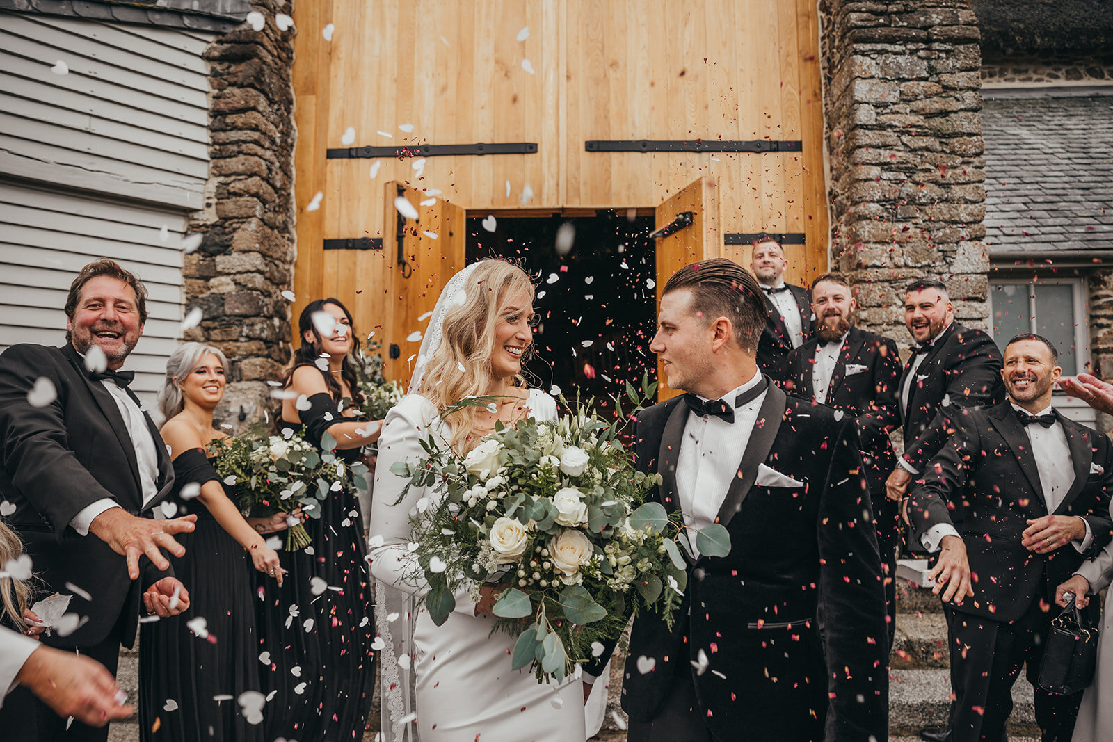 couple walking down aisle being covered in confetti