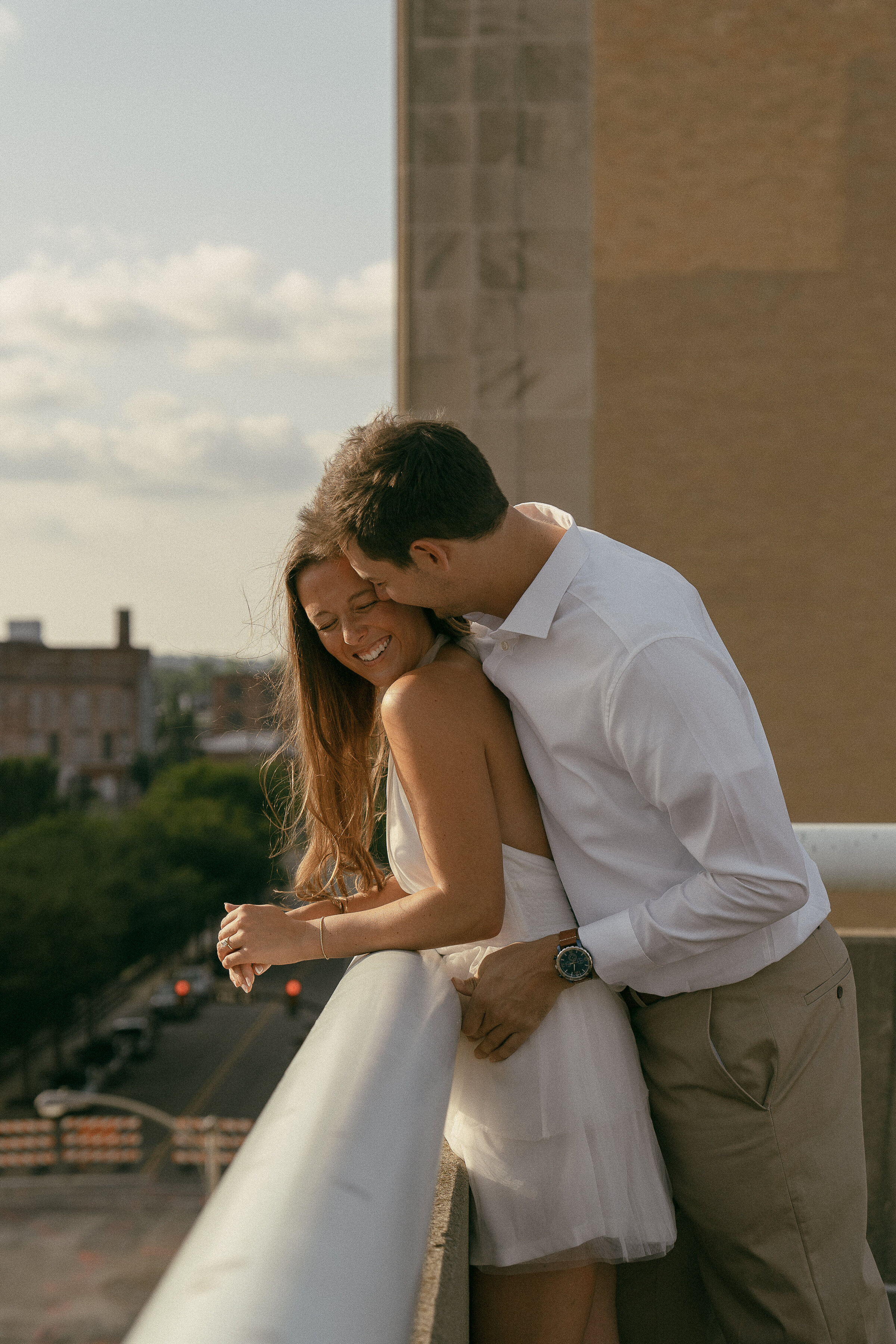 Couple sharing a romantic moment on a city rooftop.