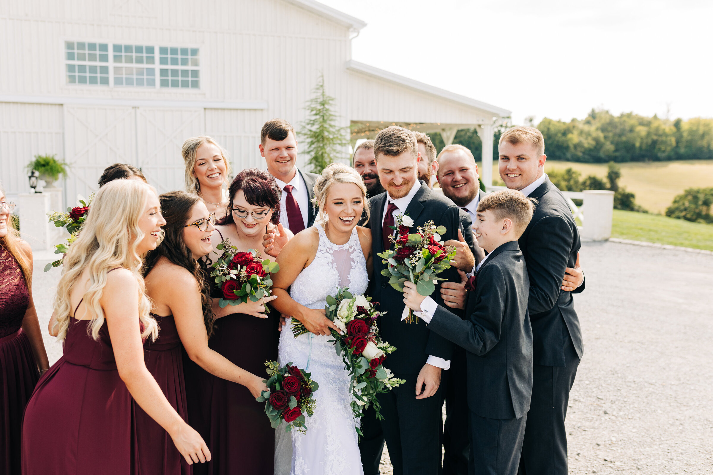 Wedding party laughing together outside of White Dove Barn