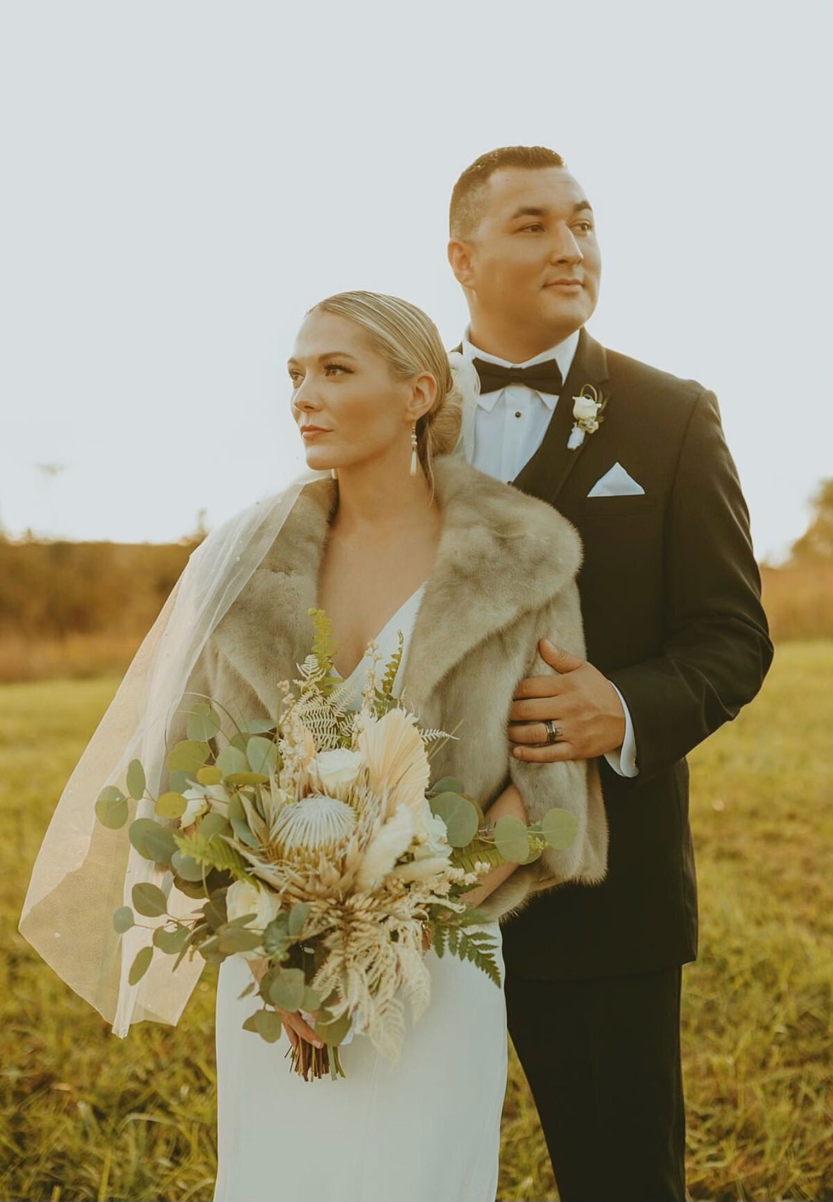 Groom wearing classic tux and bride with boho style together during golden hour