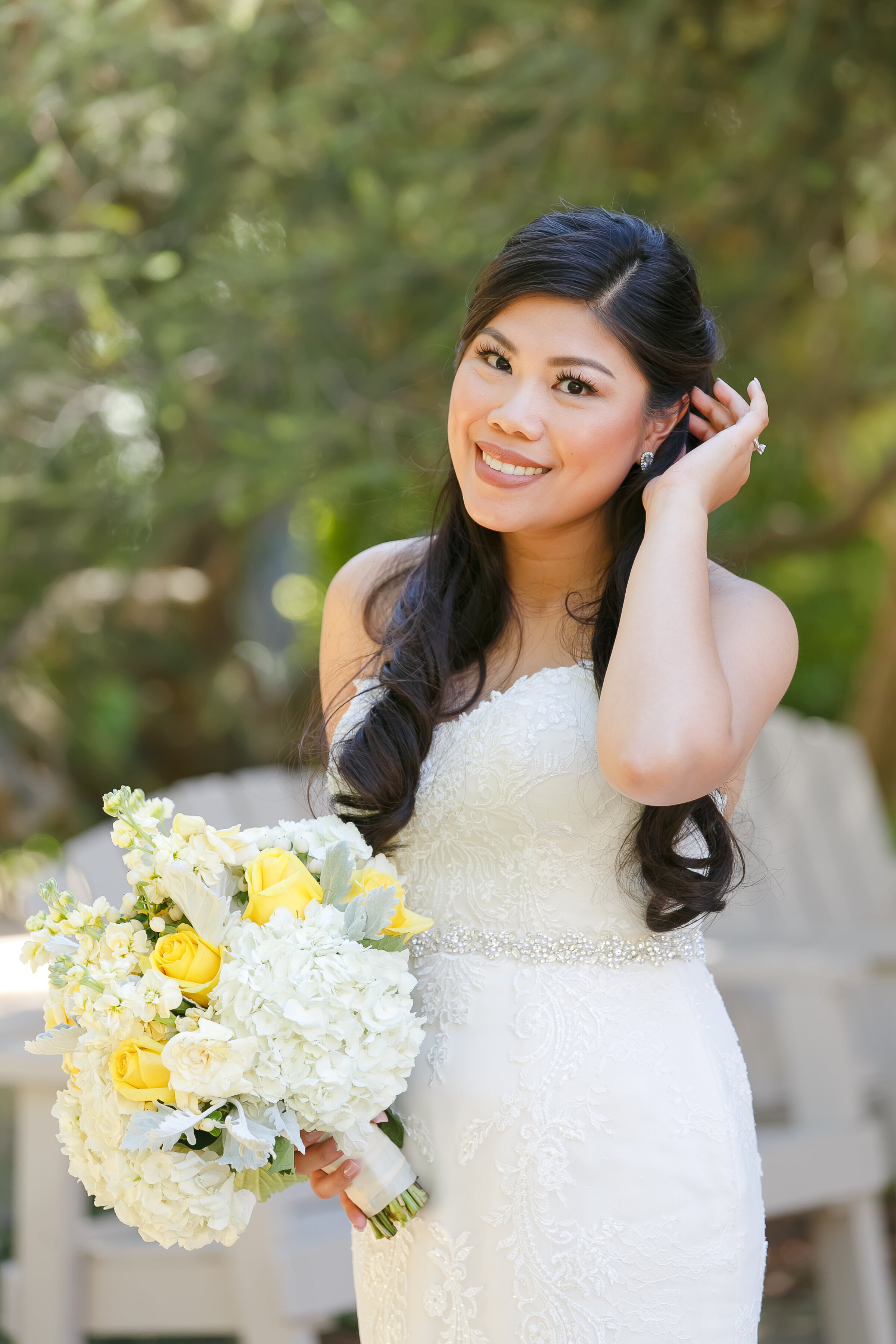 A woman in a white dress holds a bouquet of flowers.
