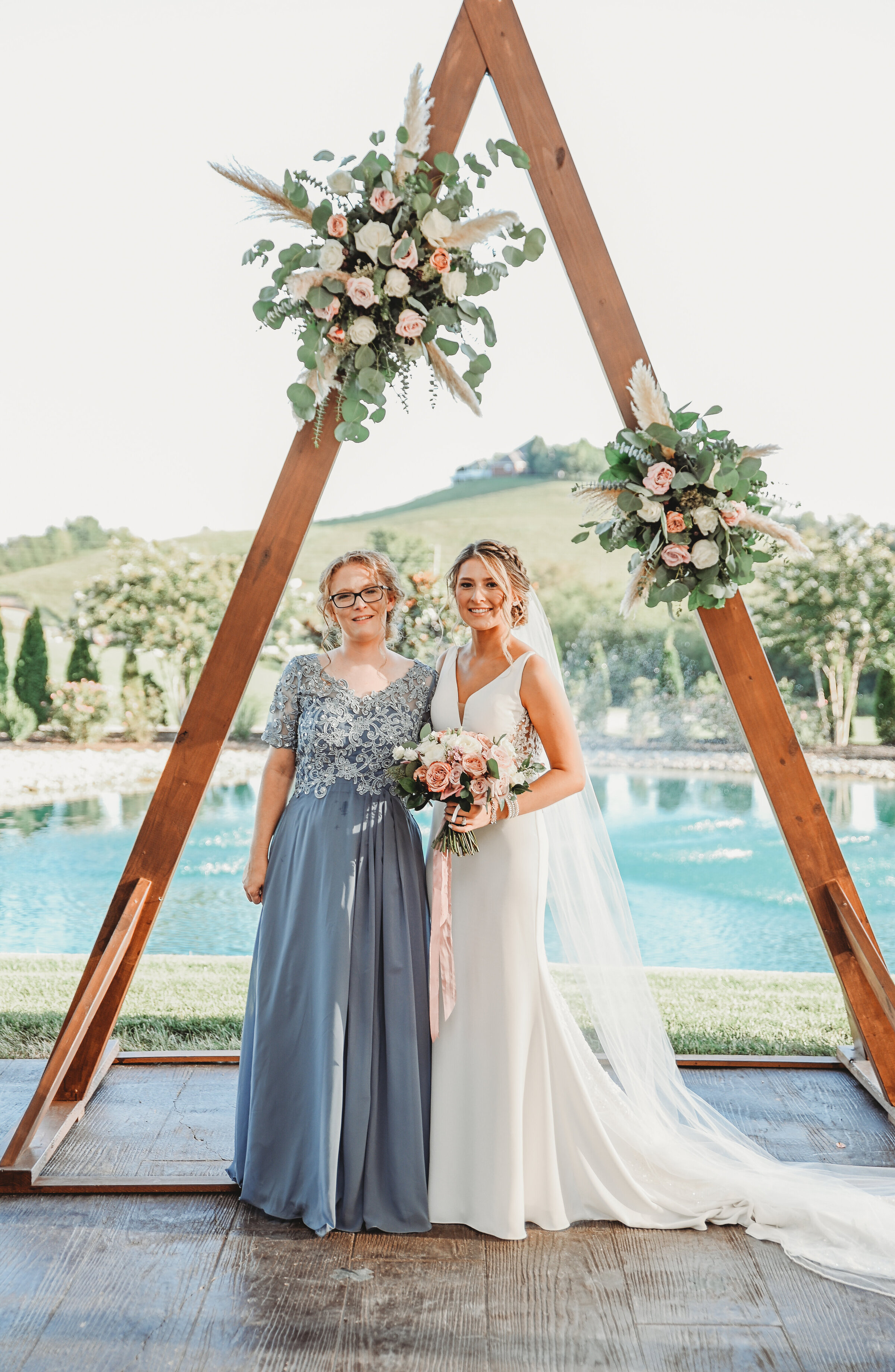 Triangle ceremony arbor with boho style flowers at White Dove Barn