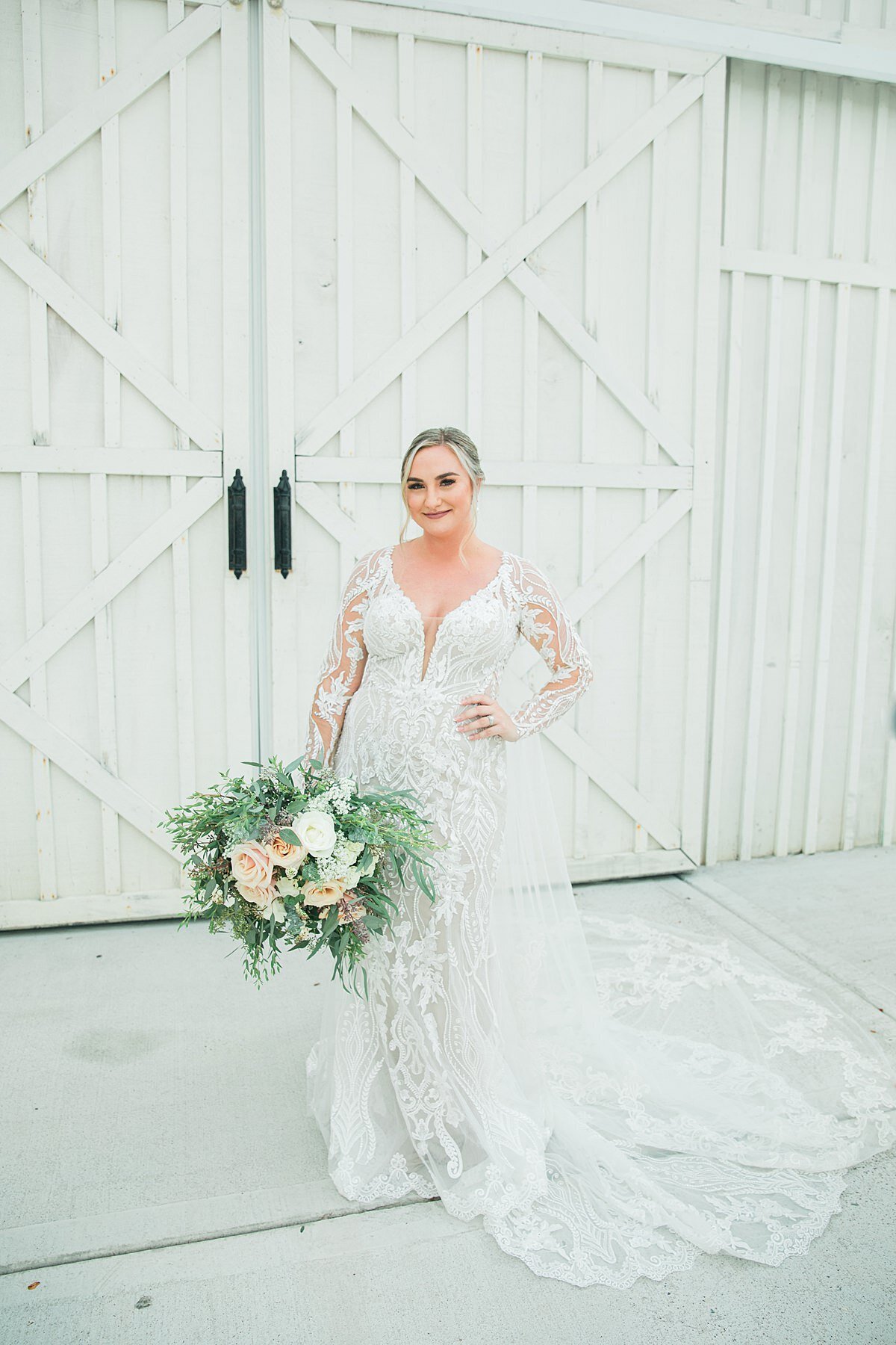Bride in long sleeve lace dress with lush bouquet