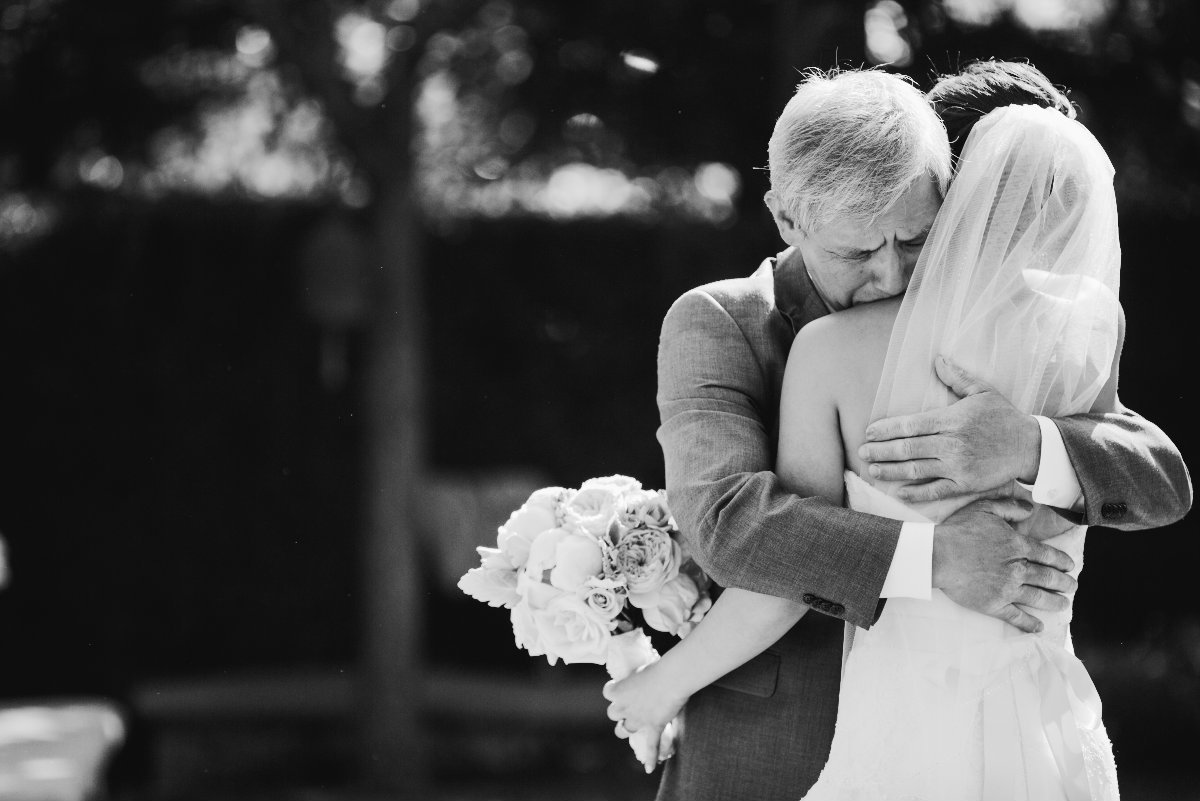 Black and white photo of father hugging his daughter as he gives her away  in California  wedding