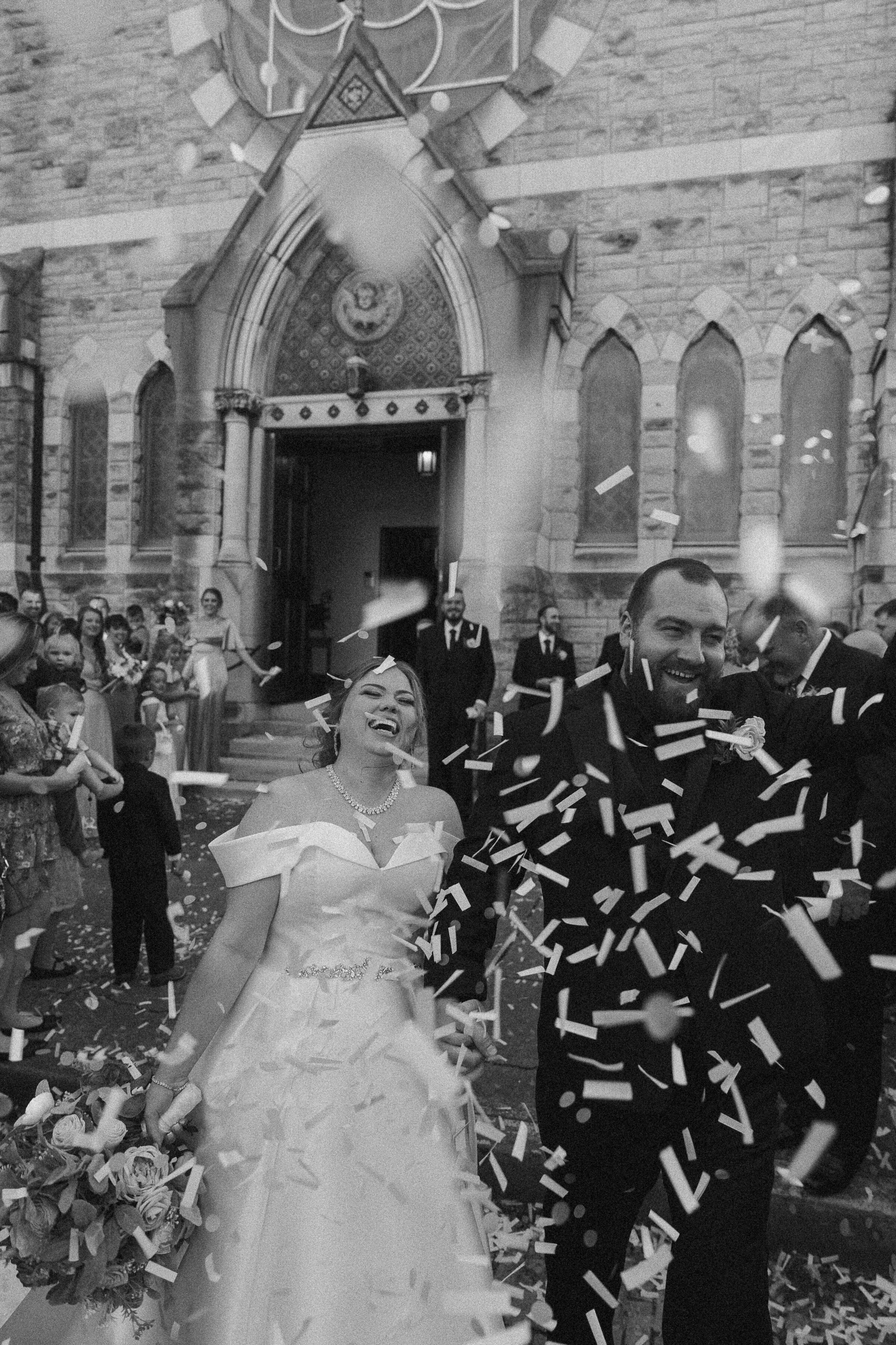 Newlyweds exiting the church amidst a shower of confetti.