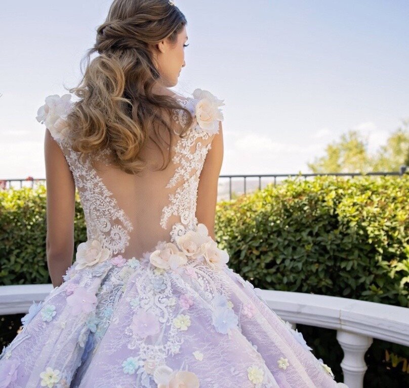 The back view of a woman in a frilly dress.