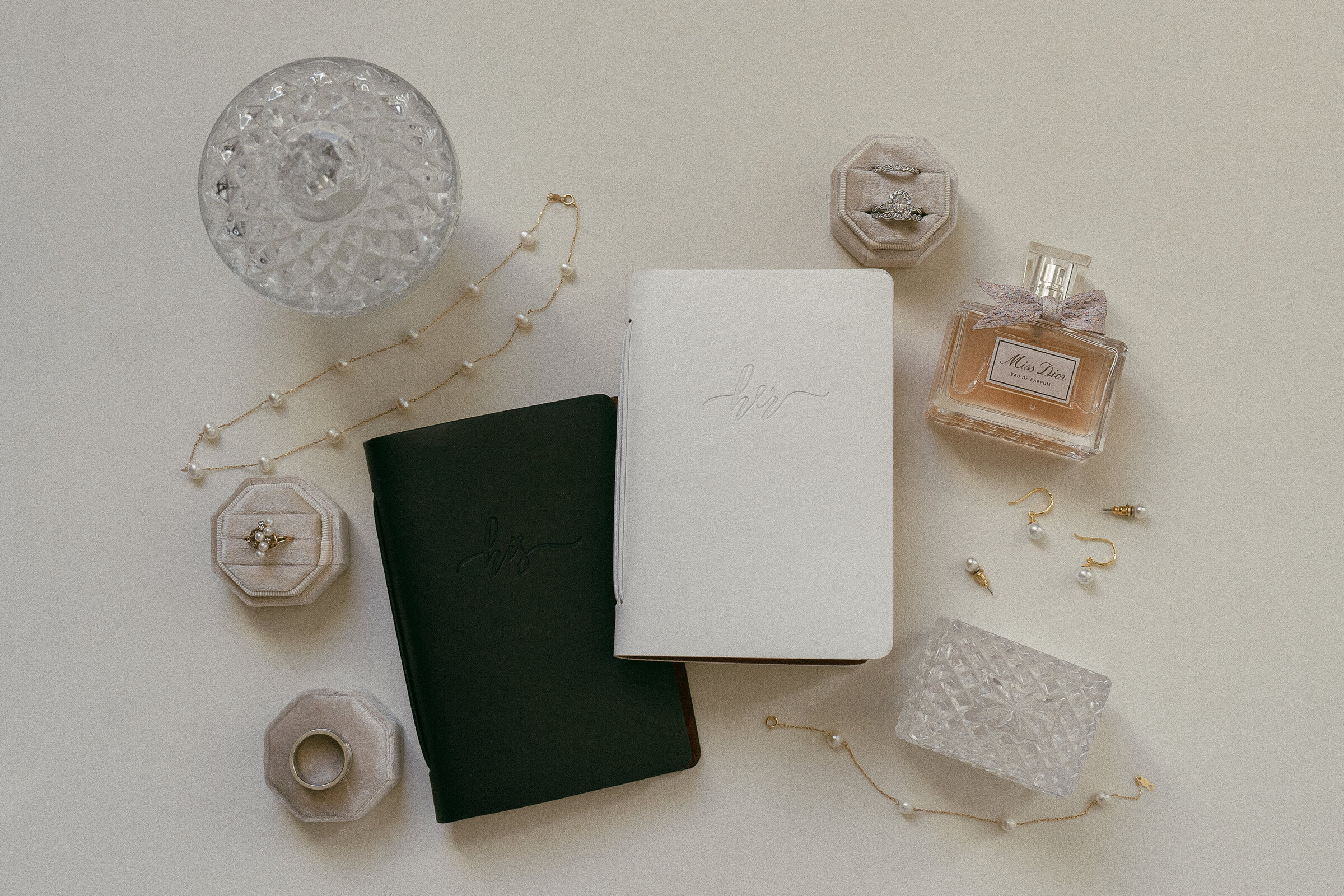 Wedding flat lay with invitations, perfume, and bridal accessories.