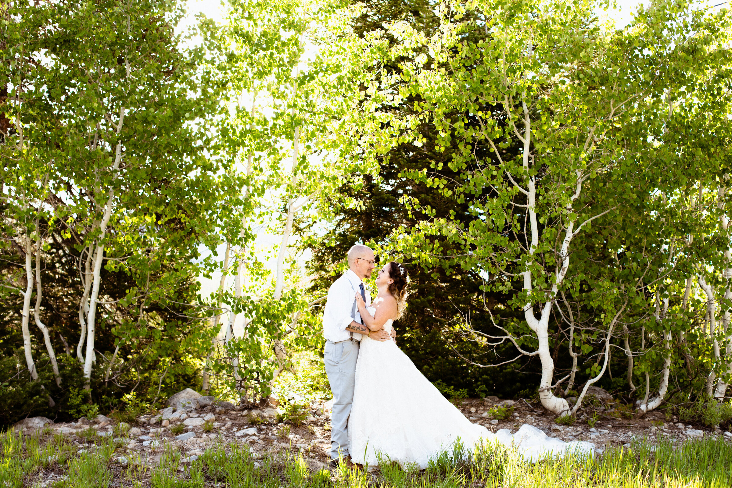 Bride and groom looking at each other and holding each other. Aspen trees surround them, they're at Solitude Mountain Resort near Park City, Utah.
