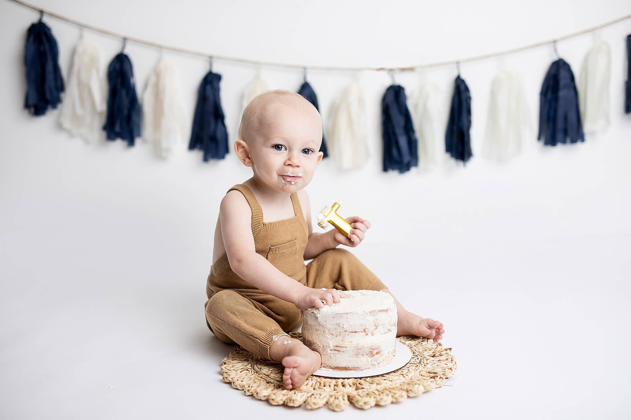 One year old boy with simple blue and white banner in the background