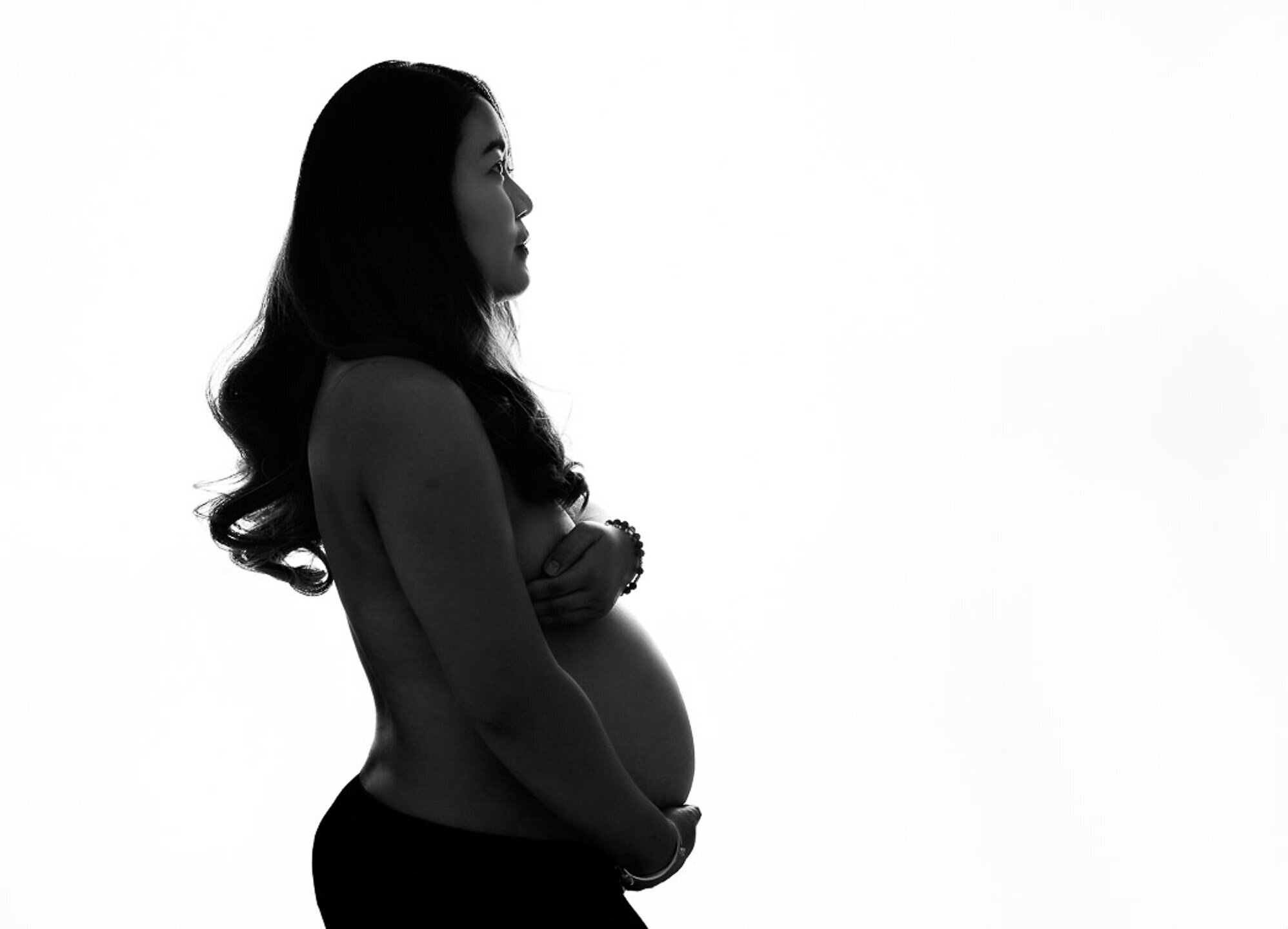Pregnant wearing black fabric posing sideview
