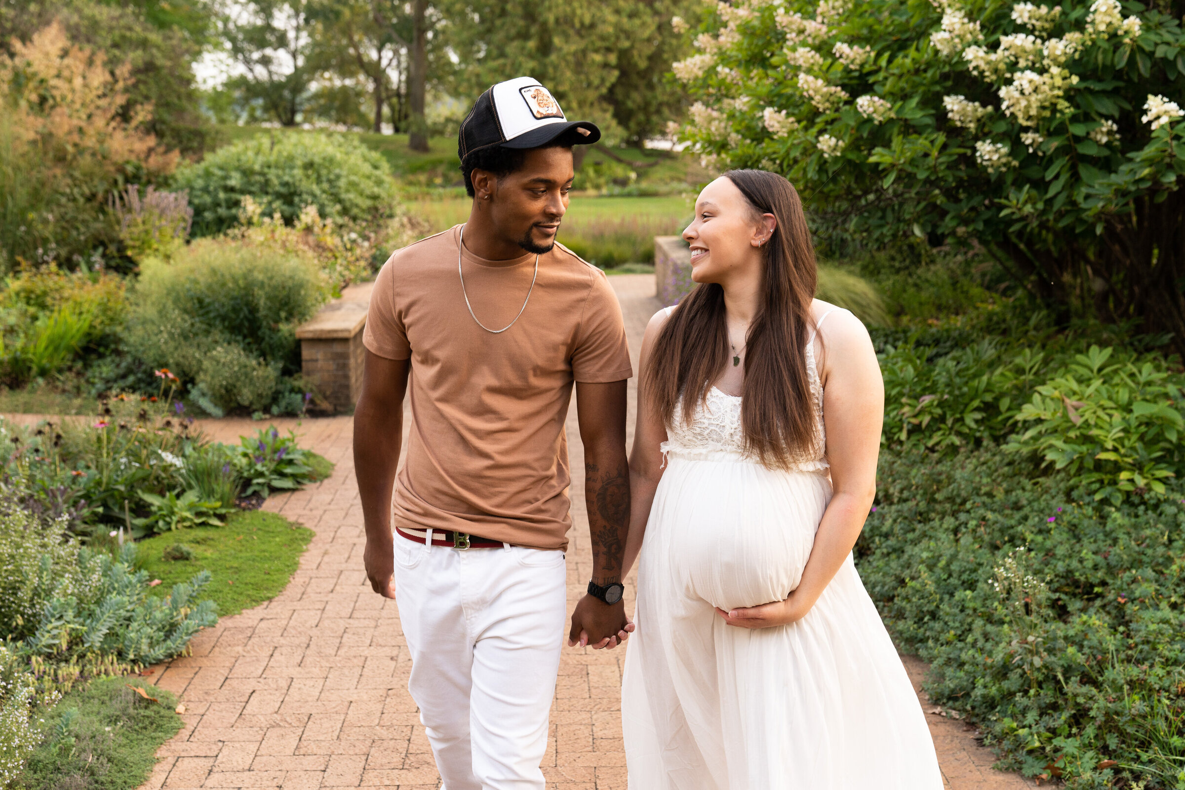 A couple walking towards the camera during their maternity session at Noerenberg Gardens in Orono, Minnesota