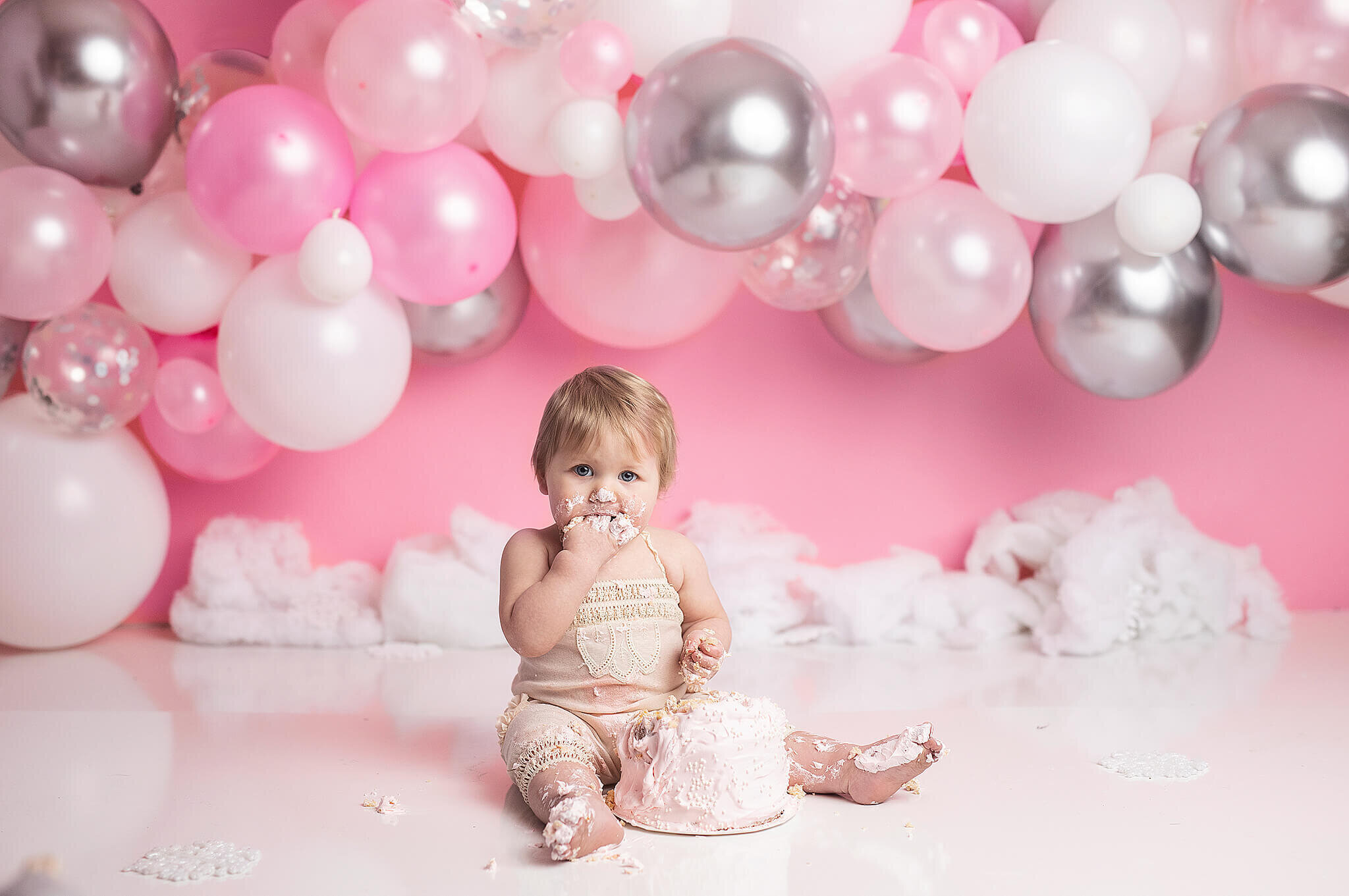 one year old cake smash, with pink background and white, pink and silver balloon arch