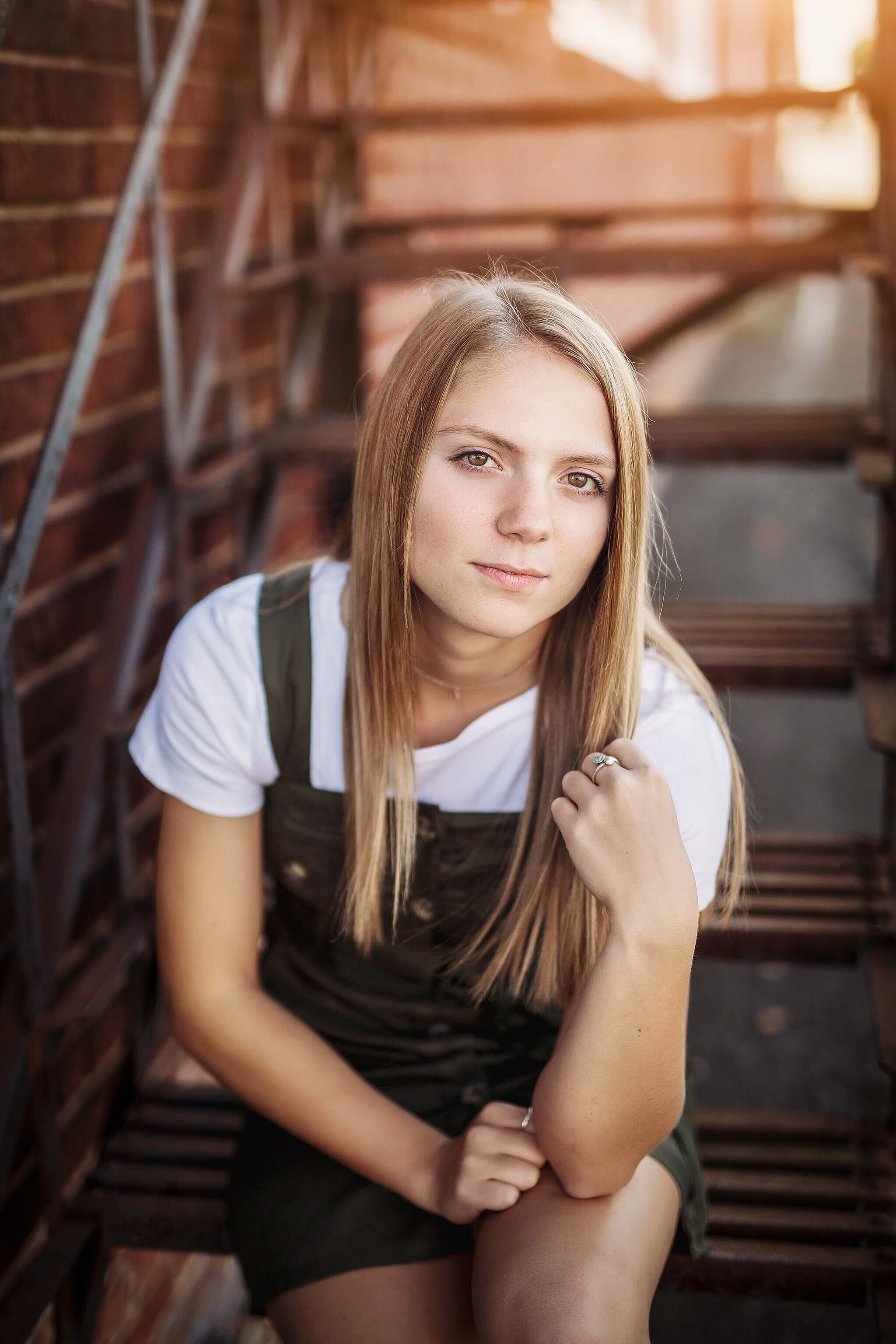 marion Ohio high school senior girl wearing jumper dress, sitting on  metal steps in mansfield Ohio