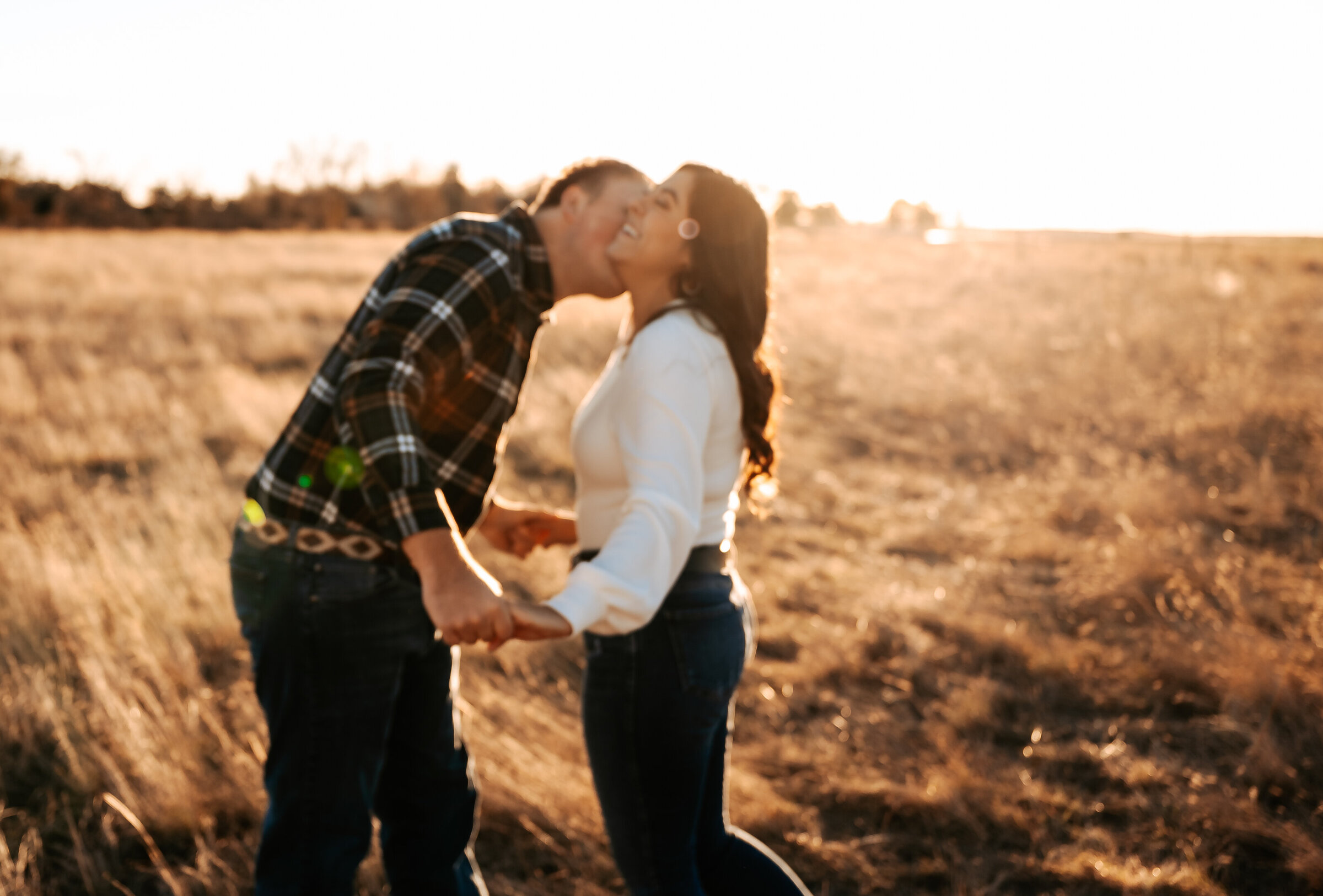 Man kisses woman's cheek in fall engagement photos